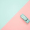 Toy car on a pastel pink and blue background, representing simplicity and retro design.